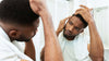 Man looking in mirror examining hair